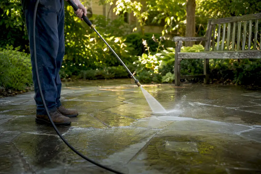 Cleaning natural stone patio with water spray