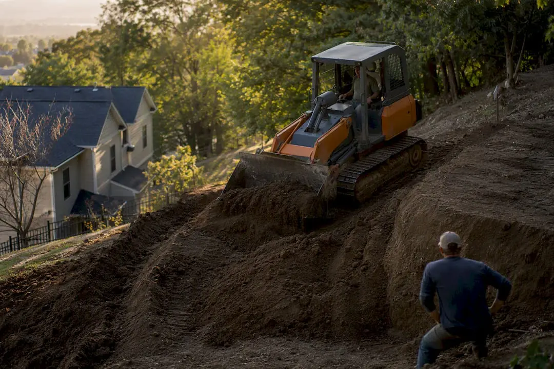 Professional grading on steep slope with equipment