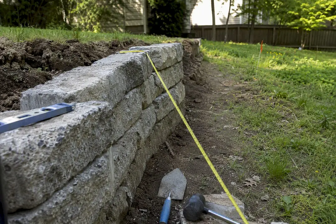 Tape measuring retaining wall setback from property line