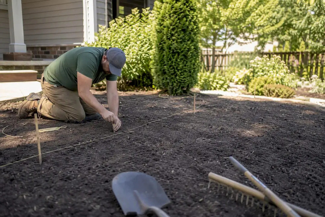 Landscaper marking soil preparation boundary