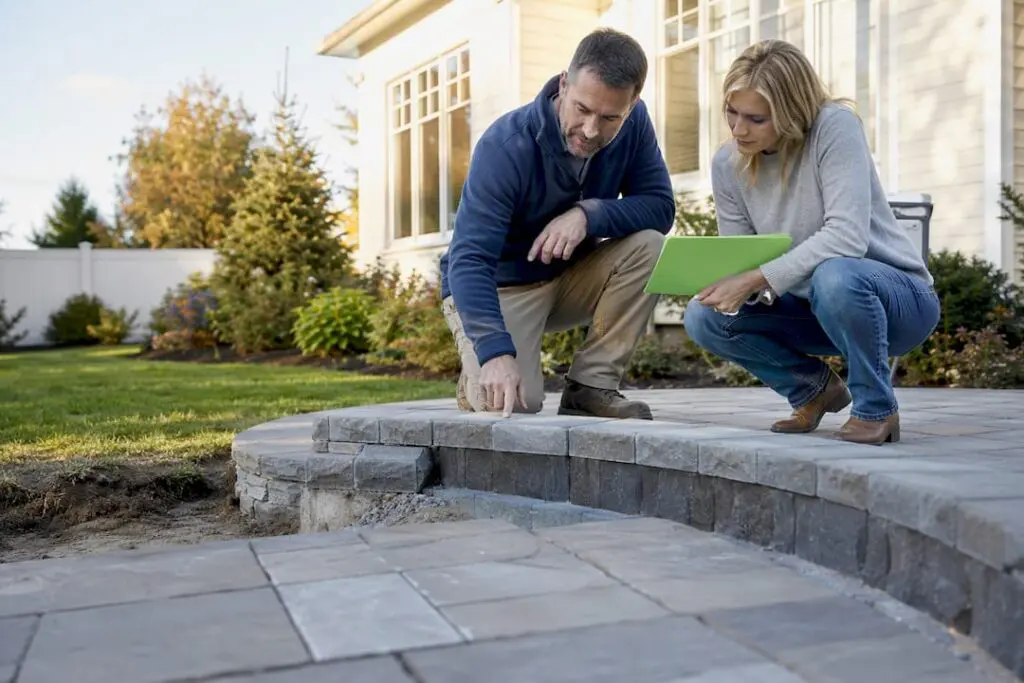 Homeowner reviewing landscape scope at patio site