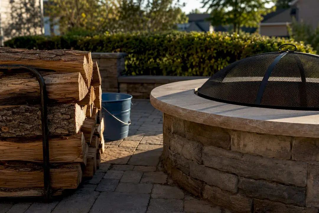 Seasoned firewood beside covered masonry fire pit