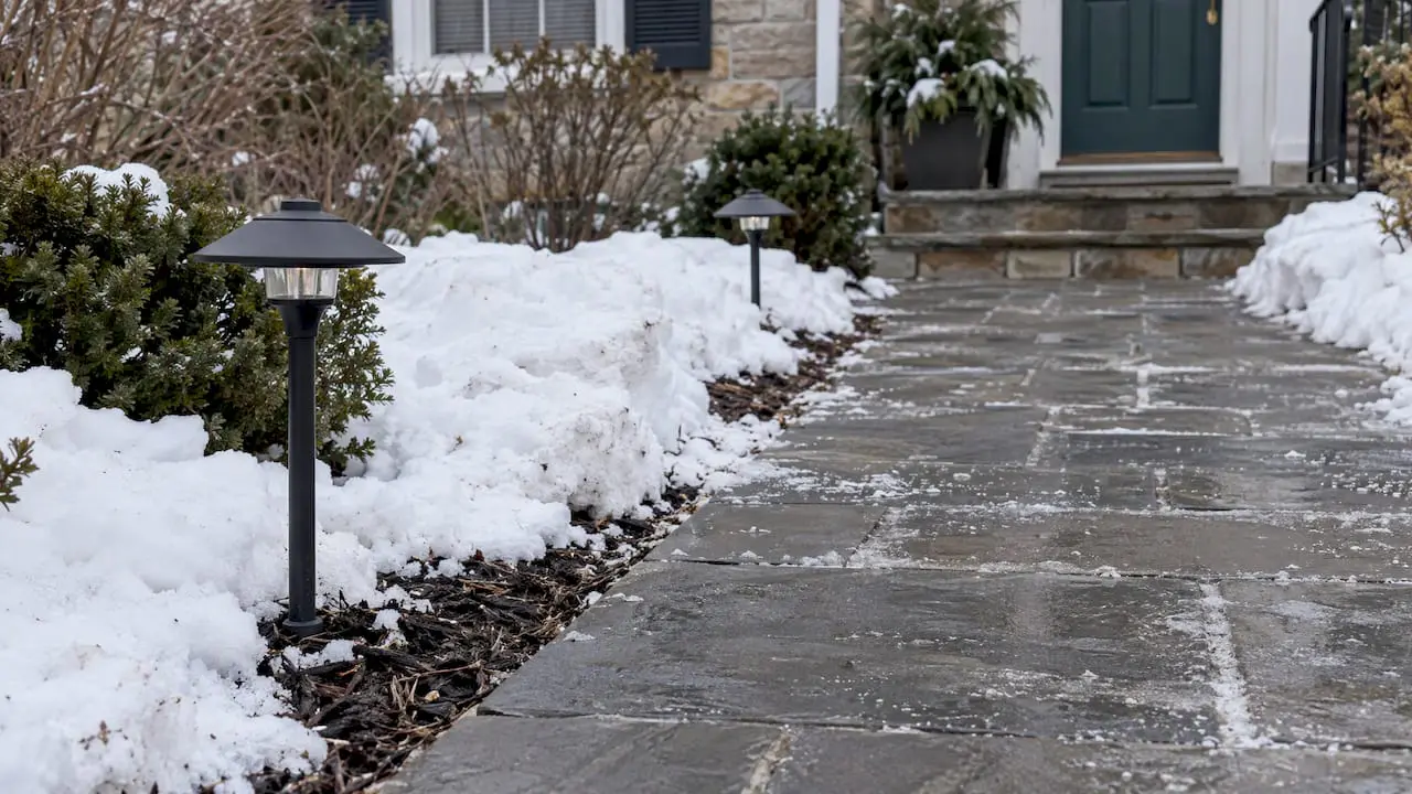 Path lights set back from winter snow piles